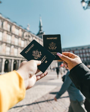 Tourists showing their U.S. passports on a sunny day, ready for international travel.