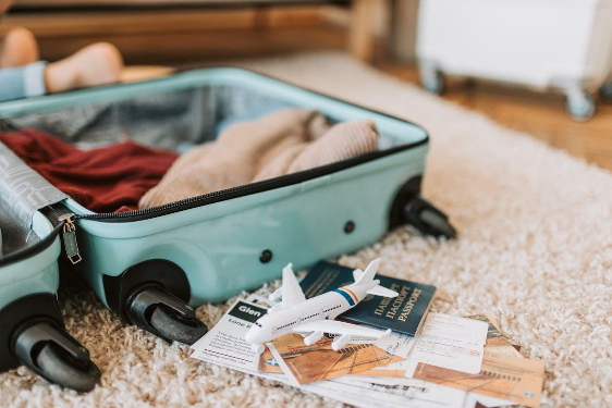 A black and green luggage bag on a brown carpet, symbolizing packing and travel readiness