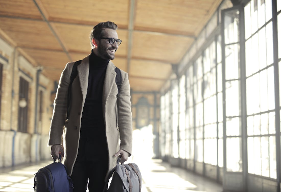 A cheerful man in a brown robe carrying a bag, symbolizing stress-free travel made possible by quick passport solutions.