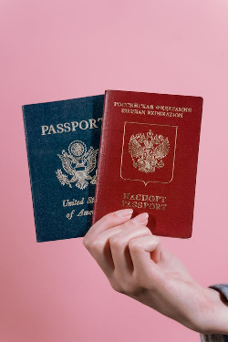 A person holding multiple passports, symbolizing dual citizenship and the ability to travel freely between countries.