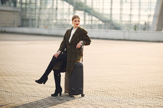 A woman outside the airport with her suitcase 