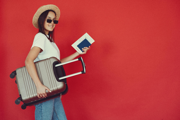 A female traveler with her suitcase and passport 
