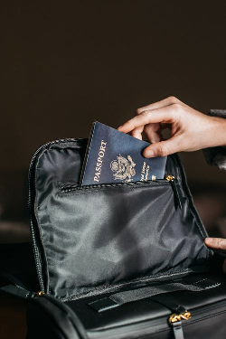 Person putting a passport in a bag